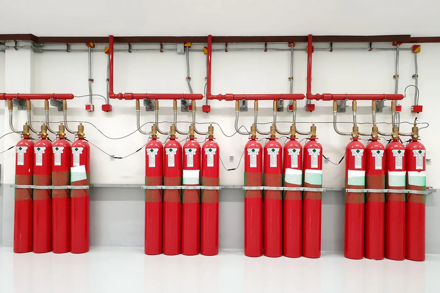 Inert gas clean agent fire suppression cylinder bank with a red distribution manifold