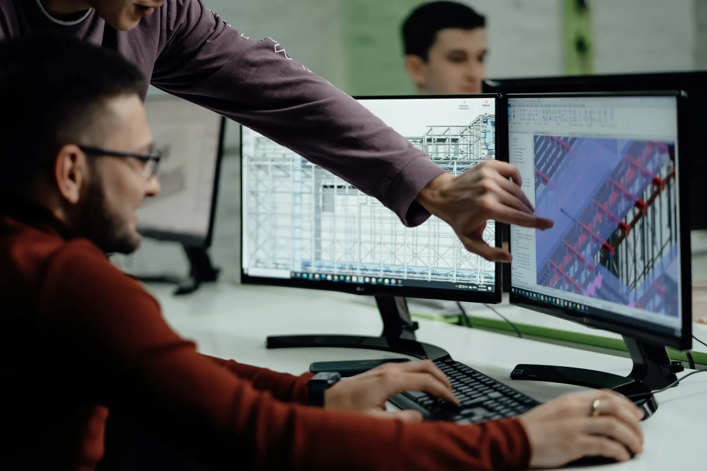 Engineers reviewing a 3D BIM structural coordination model on dual monitors