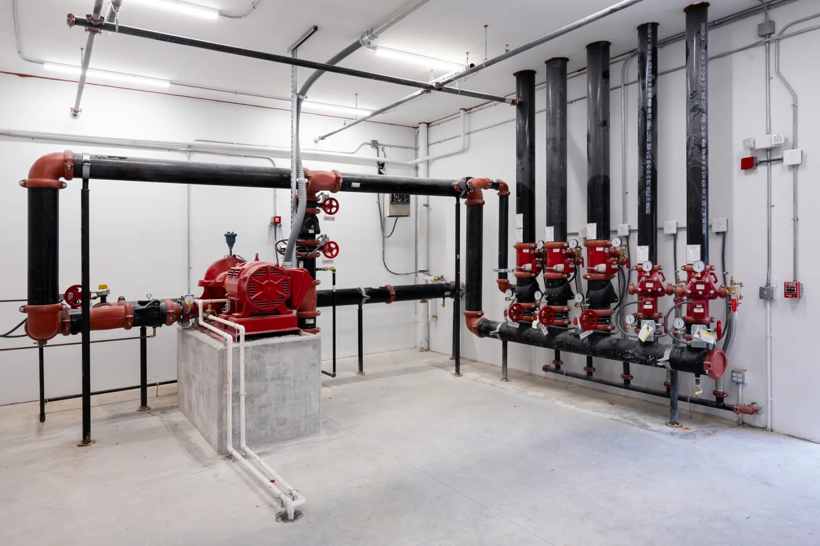 Fire pump room with a red split-case fire pump and standpipe riser manifold
