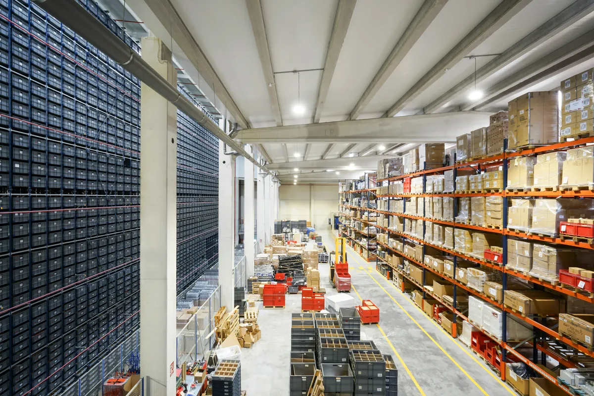 High-bay warehouse interior with automated bin storage and pallet racking