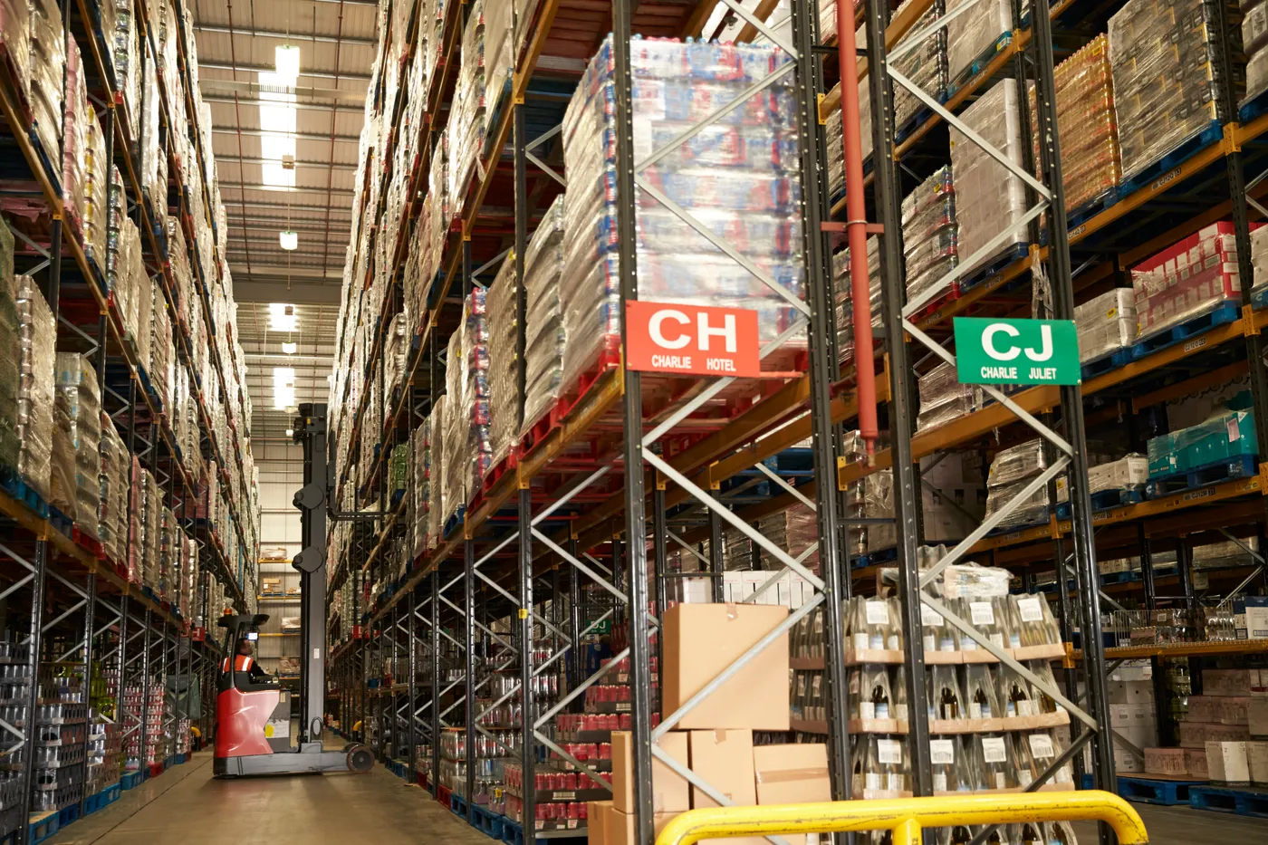 Palletized commodities in high-bay warehouse racking with classification bay labels